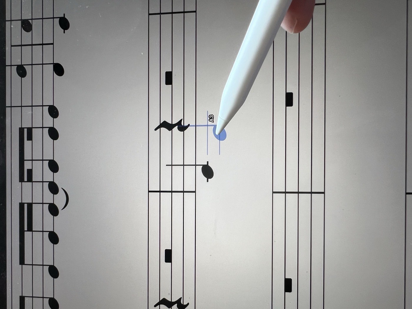 Close-up of the Apple Pencil over the staff, with the blue ghost note labelled A3 under its tip